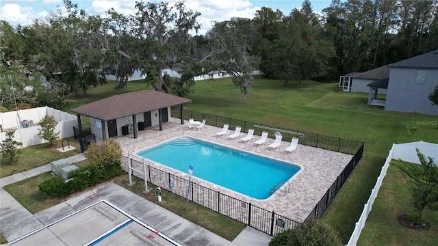 pool with fence, a lawn, and a patio