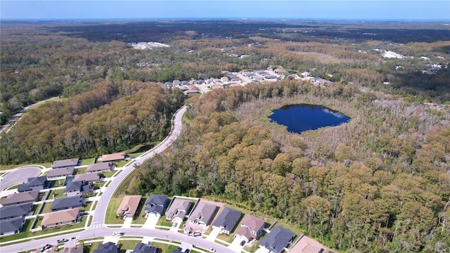 drone / aerial view featuring a water view, a residential view, and a view of trees