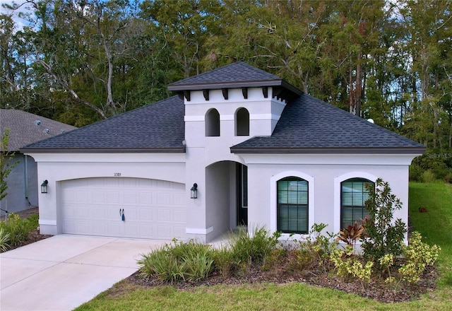 view of front of house featuring a garage, driveway, a shingled roof, and stucco siding