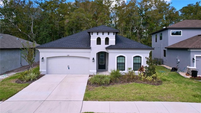 mediterranean / spanish home with driveway, roof with shingles, an attached garage, a front lawn, and stucco siding