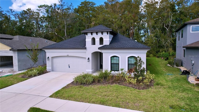 mediterranean / spanish-style home featuring concrete driveway, roof with shingles, an attached garage, a front yard, and stucco siding