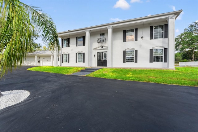 view of front of property featuring a front lawn and a garage