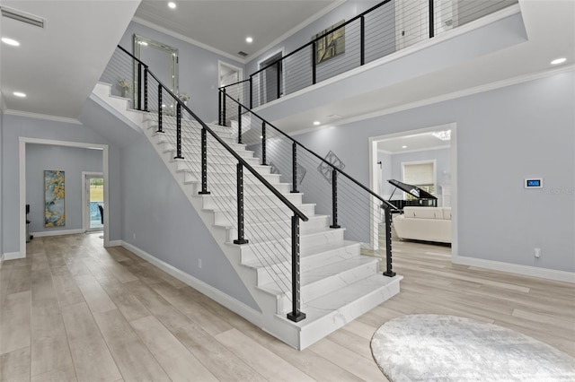 staircase with hardwood / wood-style flooring and crown molding