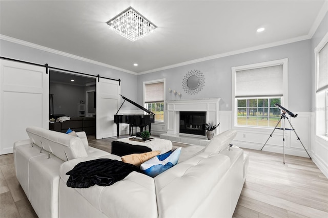 14485 Switch Back Rd, Brooksville, FL 34609 - living area featuring a barn door, light wood-style flooring, wainscoting, ornamental molding, and recessed lighting
