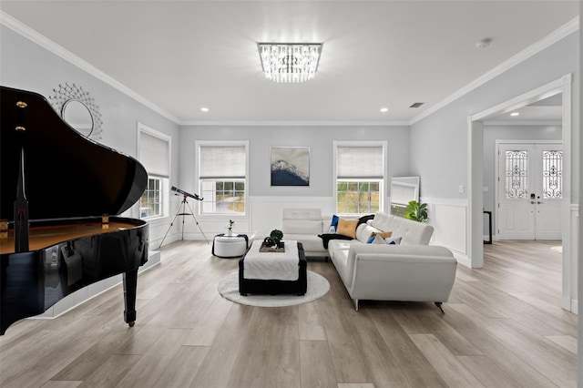 living room with light wood-type flooring, a chandelier, and crown molding