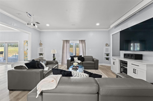 living room with light wood-type flooring, ceiling fan, ornamental molding, and plenty of natural light