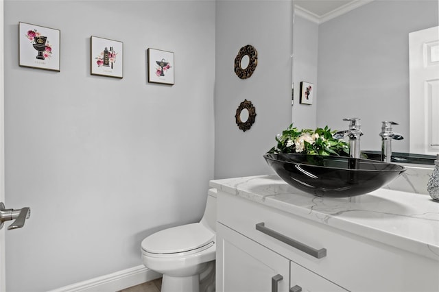 bathroom featuring vanity, toilet, and crown molding