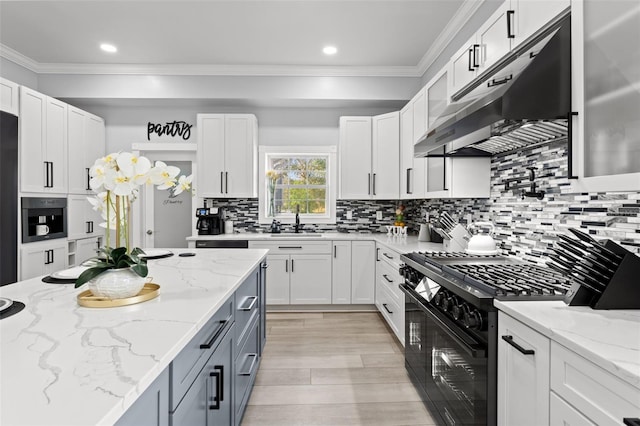 kitchen with black appliances, white cabinetry, backsplash, and light stone countertops