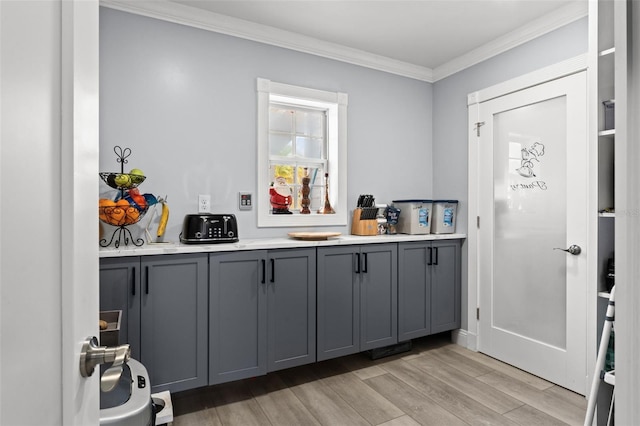 bar with crown molding, gray cabinets, and light wood-type flooring