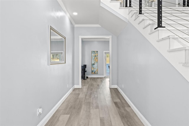 hallway with light hardwood / wood-style floors and crown molding