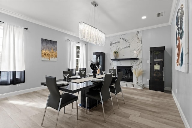 14485 Switch Back Rd, Brooksville, FL 34609 - dining room featuring crown molding, a premium fireplace, a chandelier, wood finished floors, and baseboards
