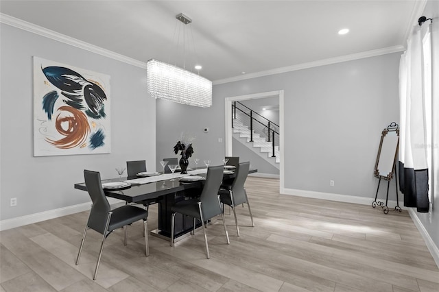 dining room featuring an inviting chandelier, ornamental molding, and light hardwood / wood-style flooring