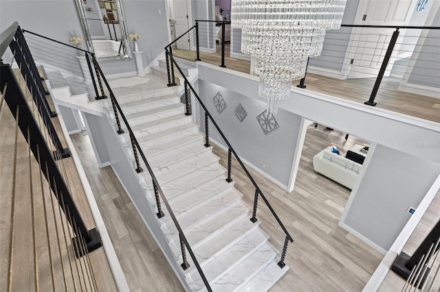 staircase featuring hardwood / wood-style flooring and a chandelier