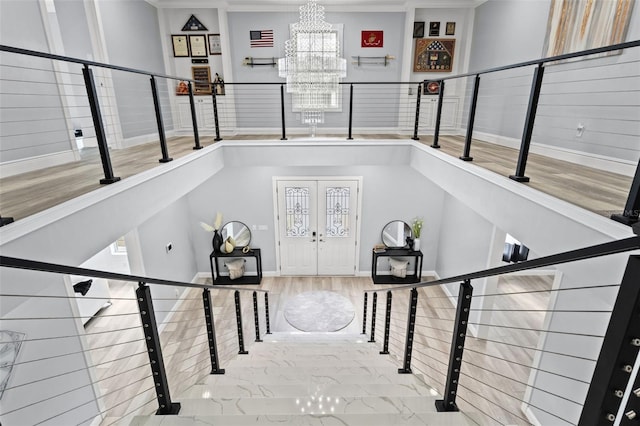 entryway featuring french doors, hardwood / wood-style floors, plenty of natural light, and a notable chandelier