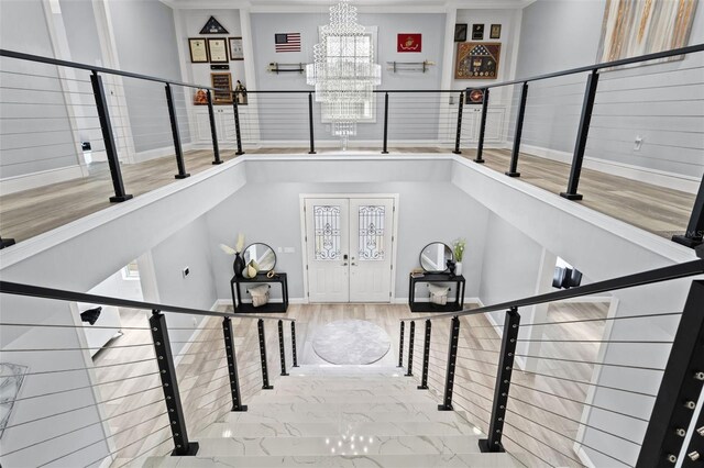 14485 Switch Back Rd, Brooksville, FL 34609 - staircase featuring a chandelier, baseboards, french doors, wood finished floors, and crown molding