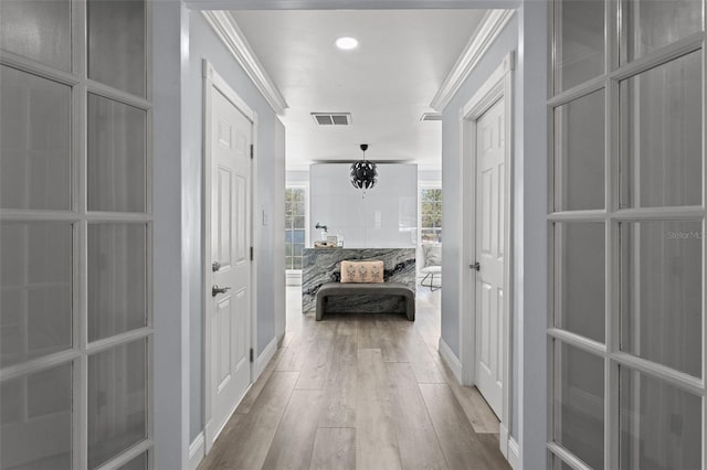 hall featuring light hardwood / wood-style flooring and crown molding