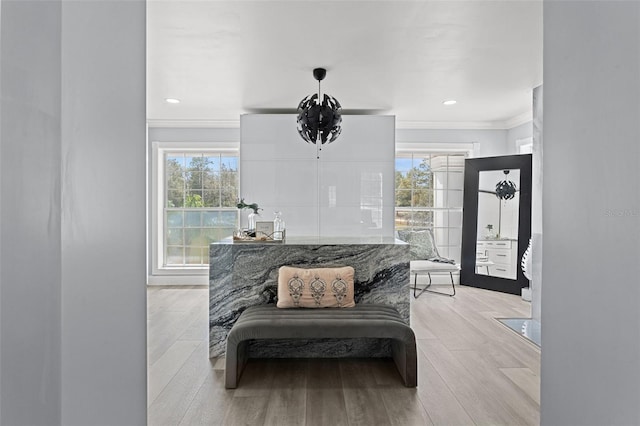 living area with light wood-type flooring and crown molding