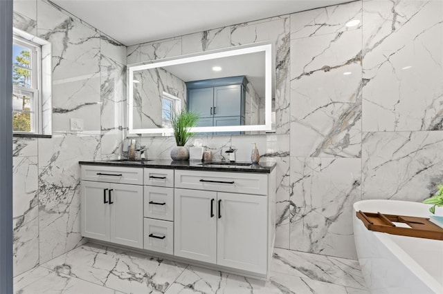 14485 Switch Back Rd, Brooksville, FL 34609 - full bath featuring marble tiled flooring, stone wall, double vanity, a freestanding tub, and tile walls