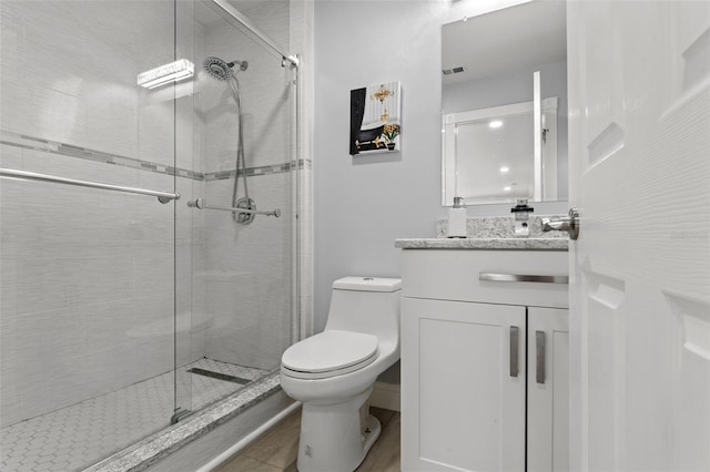 bathroom featuring toilet, tile patterned floors, vanity, and a shower with door