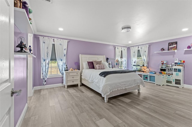 bedroom featuring ornamental molding and light wood-type flooring