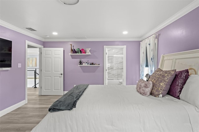 bedroom with light hardwood / wood-style floors, crown molding, and ensuite bathroom