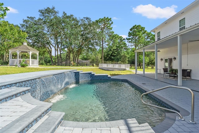 view of swimming pool featuring a patio, pool water feature, a yard, and a gazebo