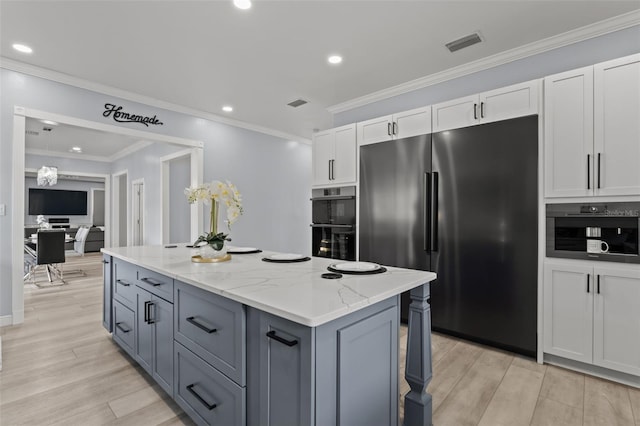 14485 Switch Back Rd, Brooksville, FL 34609 - kitchen featuring stainless steel refrigerator, a kitchen island, white cabinetry, light stone counters, and light wood-style floors
