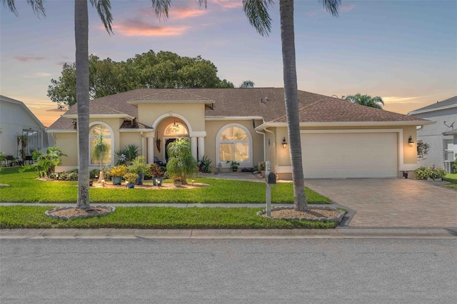 8231 Coral Creek Loop, Hudson, FL 34667 - mediterranean / spanish house with stucco siding, a garage, driveway, and a yard