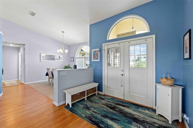 8231 Coral Creek Loop, Hudson, FL 34667 - entrance foyer featuring wood finished floors, healthy amount of natural light, a chandelier, vaulted ceiling, and baseboards