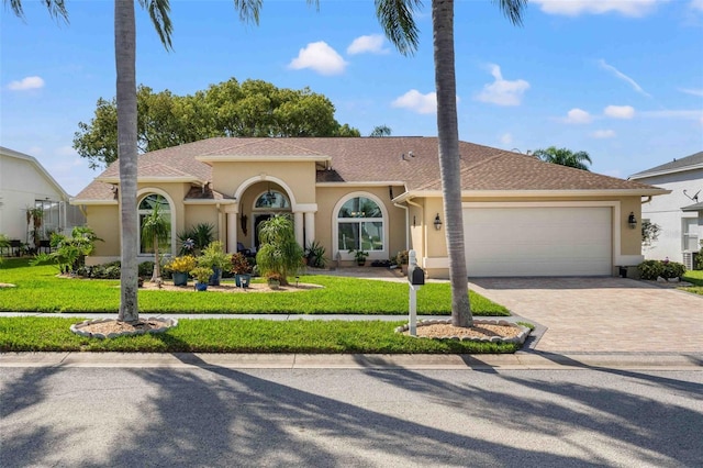 8231 Coral Creek Loop, Hudson, FL 34667 - mediterranean / spanish house featuring stucco siding, a garage, driveway, and a front yard