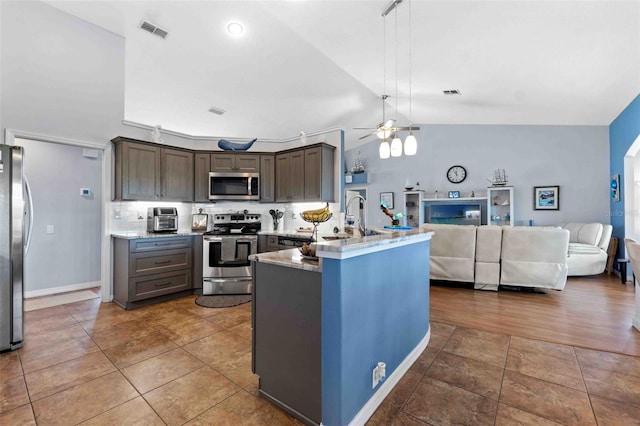8231 Coral Creek Loop, Hudson, FL 34667 - kitchen featuring appliances with stainless steel finishes, a peninsula, open floor plan, a ceiling fan, and lofted ceiling