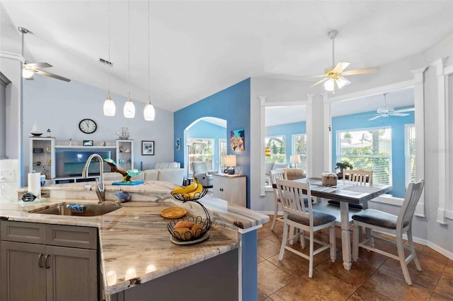 8231 Coral Creek Loop, Hudson, FL 34667 - kitchen with ceiling fan, a sink, light stone counters, gray cabinets, and vaulted ceiling