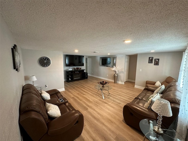 living room featuring wood-type flooring and a textured ceiling