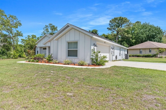 view of front of property with a garage, central AC, and a front lawn