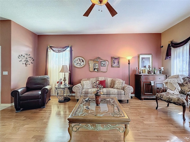 living room with ceiling fan, a healthy amount of sunlight, and light hardwood / wood-style flooring