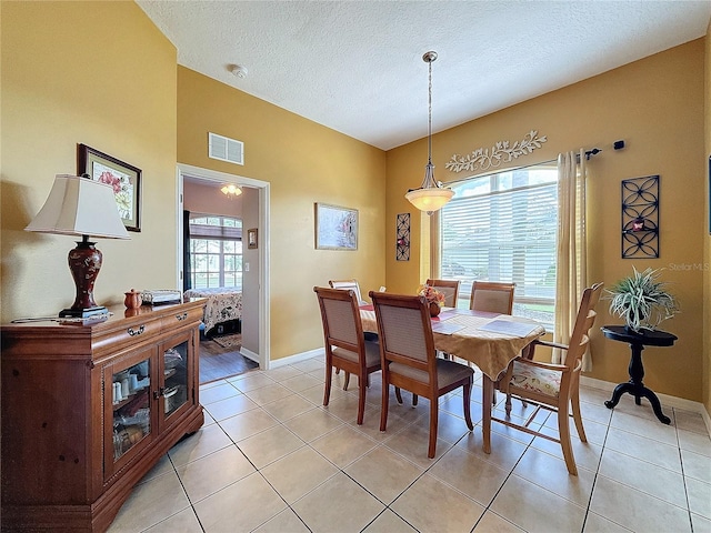 dining room with a textured ceiling and light tile patterned floors