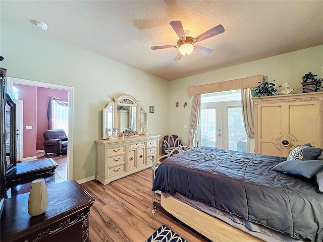 bedroom with access to outside, light wood-type flooring, a textured ceiling, and ceiling fan