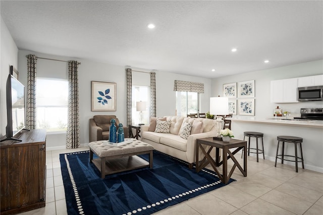 tiled living room featuring a wealth of natural light and a textured ceiling