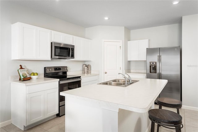 kitchen featuring stainless steel appliances, white cabinetry, sink, and an island with sink