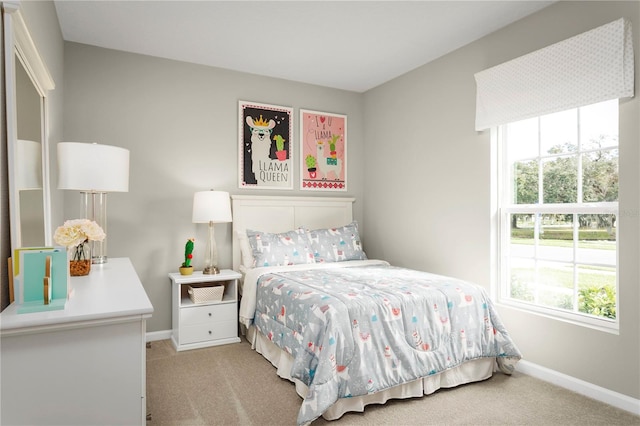 bedroom with light colored carpet and multiple windows