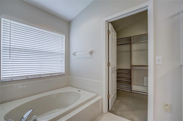 bathroom featuring tiled bath and lofted ceiling