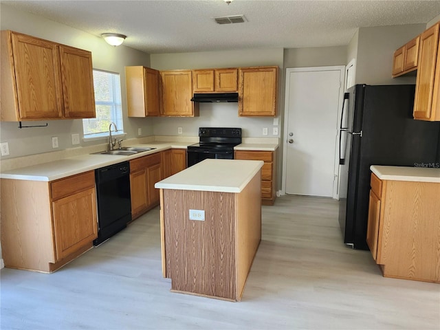 kitchen featuring light hardwood / wood-style flooring, black appliances, sink, and a center island