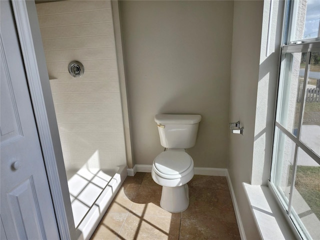 bathroom with a shower, toilet, and a baseboard heating unit