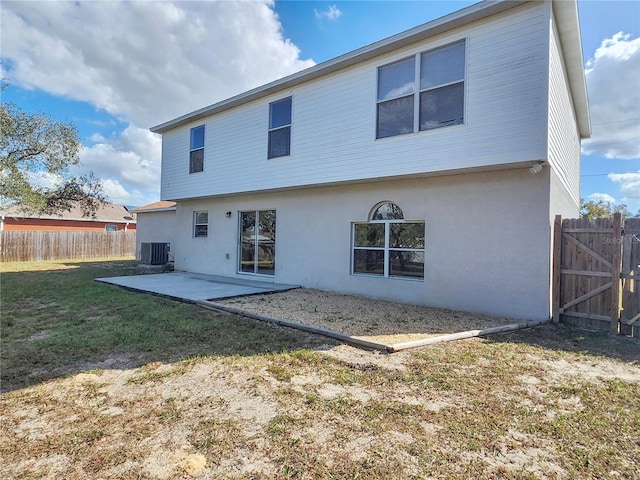 back of property with central air condition unit, a yard, and a patio