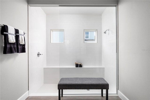 bathroom with hardwood / wood-style floors and a tile shower