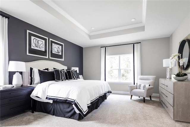 bedroom with light colored carpet and a tray ceiling