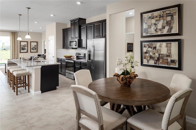 tiled dining area with a textured ceiling and sink