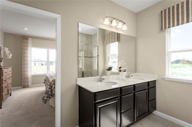 bathroom with a wealth of natural light, vanity, and a shower with door