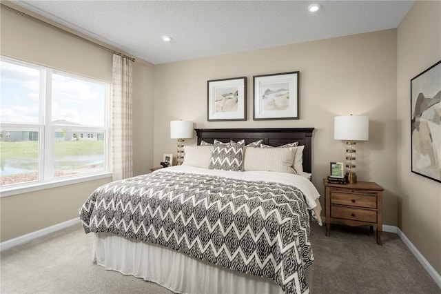 carpeted bedroom featuring multiple windows and a textured ceiling