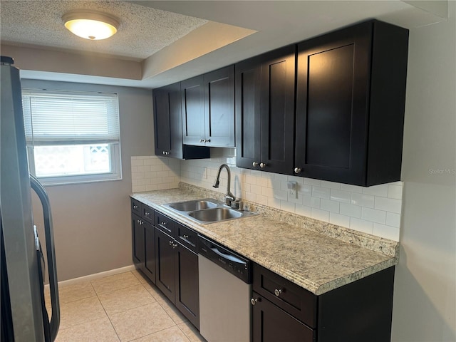 kitchen featuring refrigerator, sink, light tile patterned flooring, stainless steel dishwasher, and backsplash